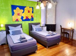 a room with two beds and a table and a painting at INTERGO Apartments in Brackel