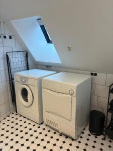 a washer and dryer in a laundry room with a window at Fiskargränden, Landskrona in Landskrona