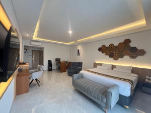 a bedroom with a large bed and a living room at Front One The Andia Boyolali in Boyolali