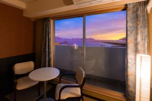 a room with a large window with a table and chairs at Hotel Sekumiya in Obama