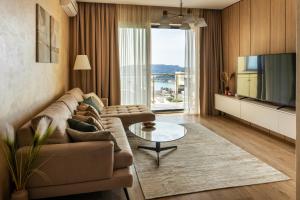 a living room with a couch and a large window at The Dream Getaway & Spa by DeVasco in Bečići