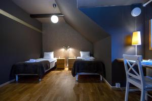 two beds in a room with blue walls and wooden floors at Port Hotel Apartments in Karlshamn