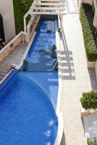 an empty swimming pool with blue water at The Dream Getaway & Spa by DeVasco in Bečići +219 photos