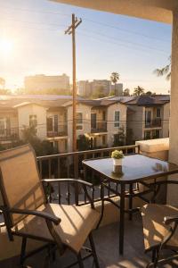 a patio with a table and chairs on a balcony at Modern 1 & 2 Bedroom Apartments Near Venice & MDR with Pool Gym & Cinema in Los Angeles