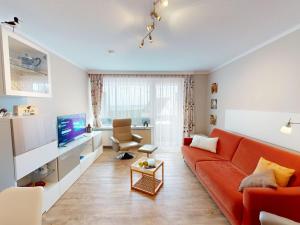 a living room with a red couch and a tv at Nautic - 307 in Cuxhaven