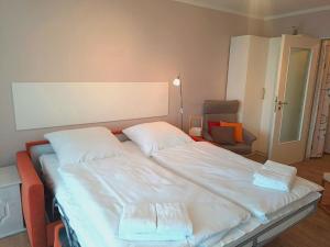 a large white bed in a room with a chair at Nautic - 307 in Cuxhaven +15 photos