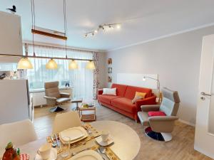 a living room with a red couch and a table at Nautic - 307 in Cuxhaven