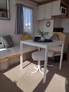 a white table and chair in a small room at Caravan in Chapel Skegness in Chapel Saint Leonards
