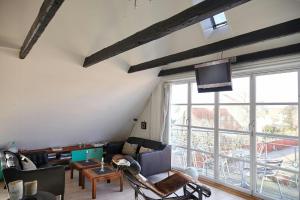 a living room with a couch and a large window at Spacious House In Skagen in Skagen