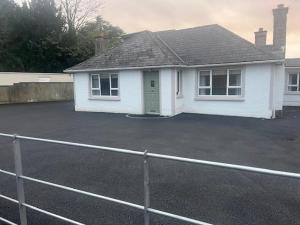 a white house with a parking lot in front of it at Brocklamont cottage in Ballymena