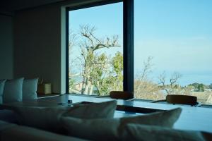 a room with a table and a large window at Hiire IZU FUTO in Ito