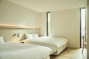 a hotel room with two beds and a window at Hiire IZU FUTO in Ito