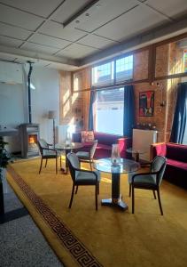 a living room with chairs and tables and a fireplace at Het Ambachtshuis Warffum in Warffum