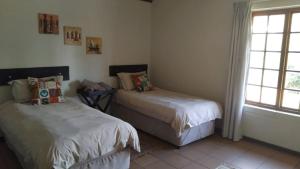 a bedroom with two beds and a window at Trout Ways in Waterval Boven