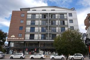 ein Gebäude, vor dem Autos parken in der Unterkunft Evdirhan Otel in Dosemealti + 9 Fotos