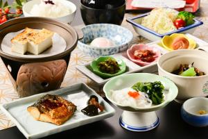 a table with plates of food and bowls of food at Hotel Sekumiya in Obama