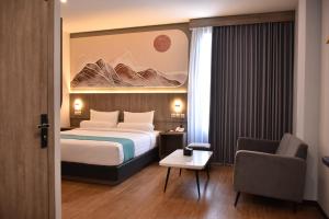 a hotel room with a bed and a chair at Front One Luxe Hotel Solo in Solo +72 photos