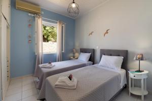 two beds in a room with blue walls at Villa Labovitsa in Vlachopoulátika