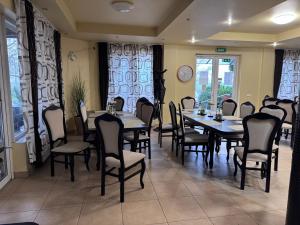 a dining room with tables and chairs and windows at Pensiunea Rodica in Nădlac