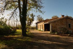 an old brick house with a tree in front of it at La Casa M-maison idéale pour groupes familles amis 12 personnes au calme avec piscine in Sainte-Hélène