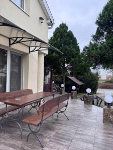 a patio with two wooden benches and an umbrella at Pensiunea Rodica in Nădlac +10 photos