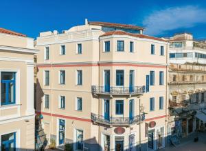 a tall white building with balconies on a street at Lotus Center Inn in Athens