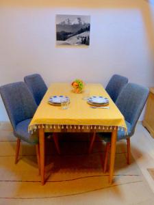 a table with blue chairs and a yellow table cloth at Haus Berger in Bad Reichenhall
