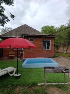 a house with a swimming pool and an umbrella at Lankaran Boutique Home in Lankaran
