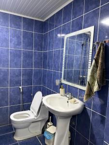 a blue tiled bathroom with a toilet and a sink at Lankaran Boutique Home in Lankaran +15 photos