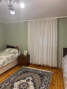 a bedroom with a bed and a rug and a window at Lankaran Boutique Home in Lankaran