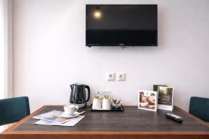 a wooden table with a television on a wall at Lotus Center Inn in Athens