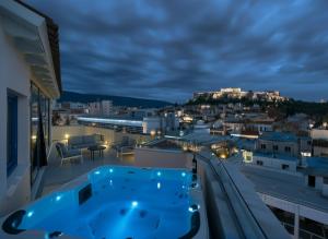 a hot tub on the roof of a building at night at Lotus Center Inn in Athens