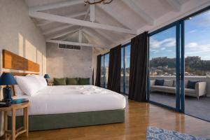 a bedroom with a large bed and large windows at Lotus Center Inn in Athens +27 photos