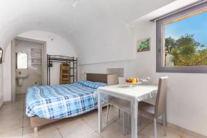 a bedroom with a bed and a table and a table and chairs at Trulli degli Augelli by BarbarHouse in San Michele Salentino +38 photos