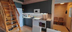 a kitchen with black cabinets and a staircase in a room at Villa Lotta in Virttaa