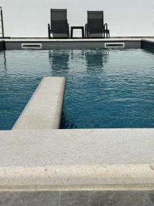 two chairs sitting next to a swimming pool at Astrid Deluxe in Novalja