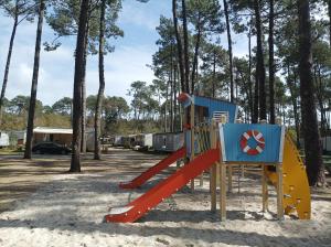a playground with a slide in the sand at camping les oyats in Seignosse