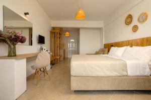 a bedroom with a large white bed and a desk at Nel Mare Studios in Laganas