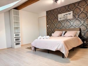 a bedroom with a large bed with pink pillows at Votre cocon vosgien in Saint-Étienne-lès-Remiremont