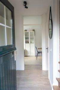 a hallway with a door leading to a dining room at Luxe wellnesshuis op de Veluwe in Lunteren +20 photos