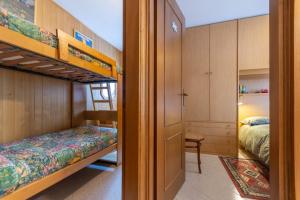 a bedroom with two bunk beds and a desk at Appartamento Mondeval in Selva di Cadore