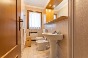 a small bathroom with a toilet and a sink at Appartamento Mondeval in Selva di Cadore +16 photos