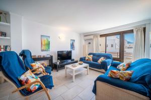 a living room with two blue couches and a tv at Piso Marc by Sealand Villas in Port de Pollensa