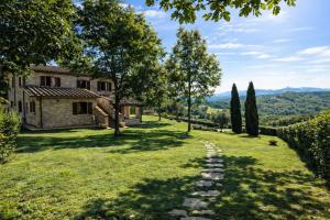 a garden with a stone path leading to a house at Scappo in Umbria, La dolce Godera in Lugnano in Teverina