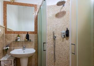 a bathroom with a sink and a shower with a mirror at Hostly G&G Home in Pisa