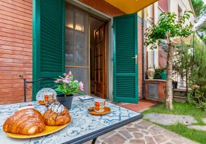 a table with bread and croissants on a patio at Hostly G&G Home in Pisa
