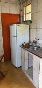 a kitchen with a white refrigerator and a sink at Hospedagem up home Natureza e Simplicidade in Barra de Guaratiba +43 photos
