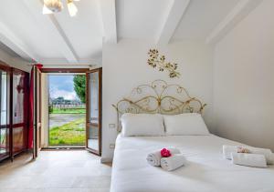 a bedroom with a white bed with towels on it at Hostly G&G Home in Pisa