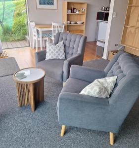 a living room with two couches and a table at Addictive View - Lakeside Studio in Rotorua