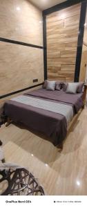 a large bed in a room with a wooden wall at Dr Rajam's Gastro Garden in Vallam